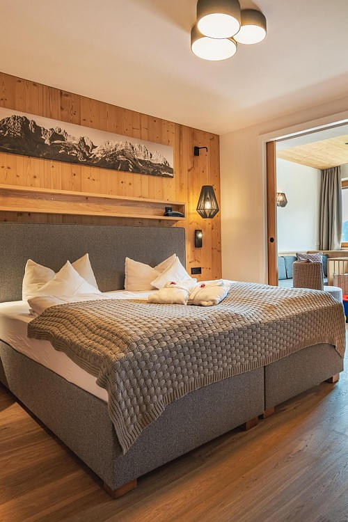 Komfortables Doppelzimmer mit Holzwand und gemütlicher Beleuchtung