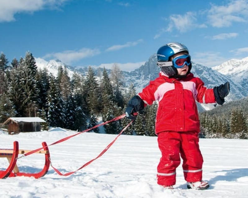 Kinder genießen das Rodeln im Schnee in den Kitzbüheler Alpen